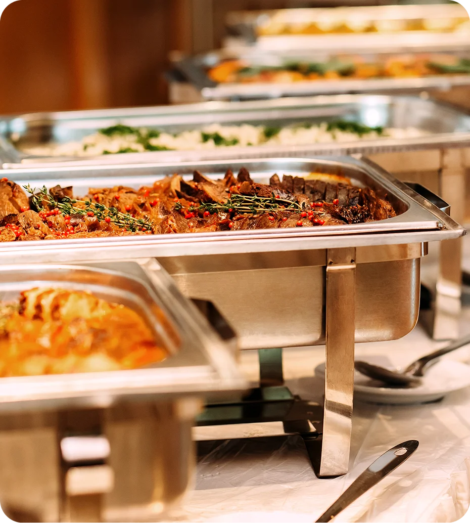 Buffet with assorted dishes in metal trays.