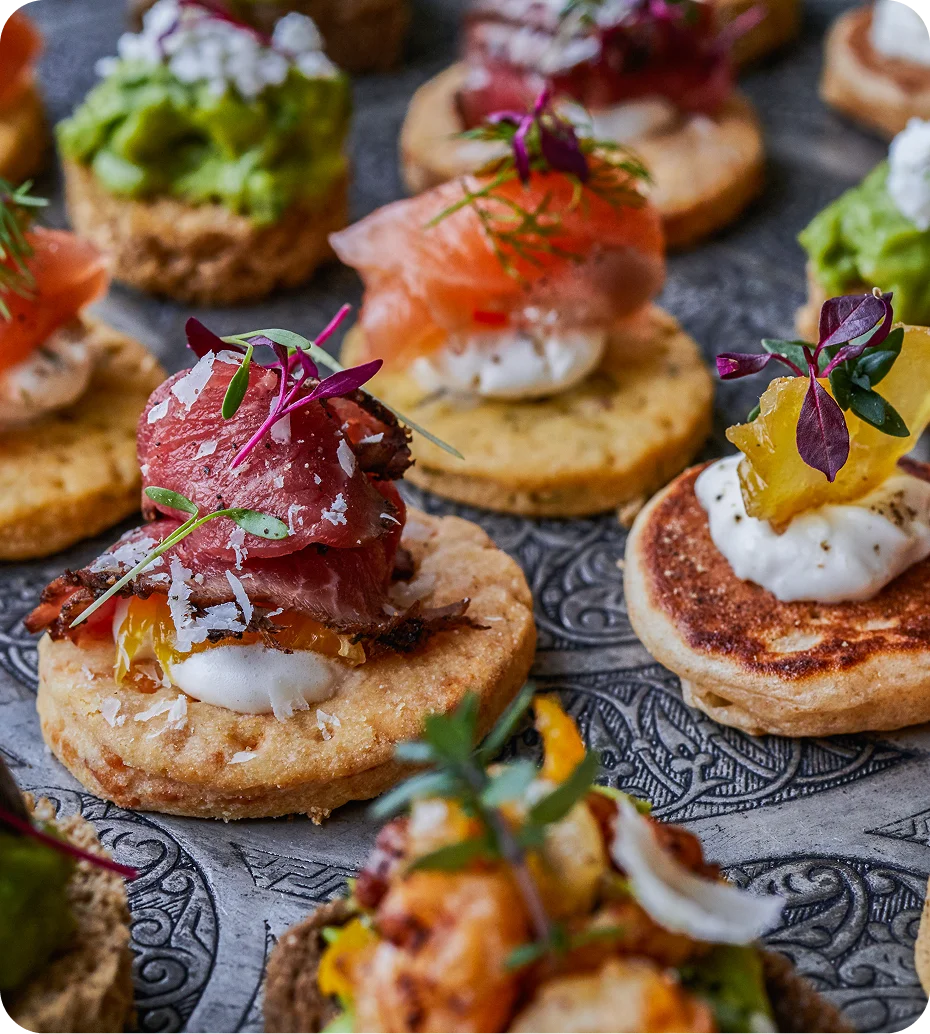 Gourmet appetizers with assorted toppings on crackers.