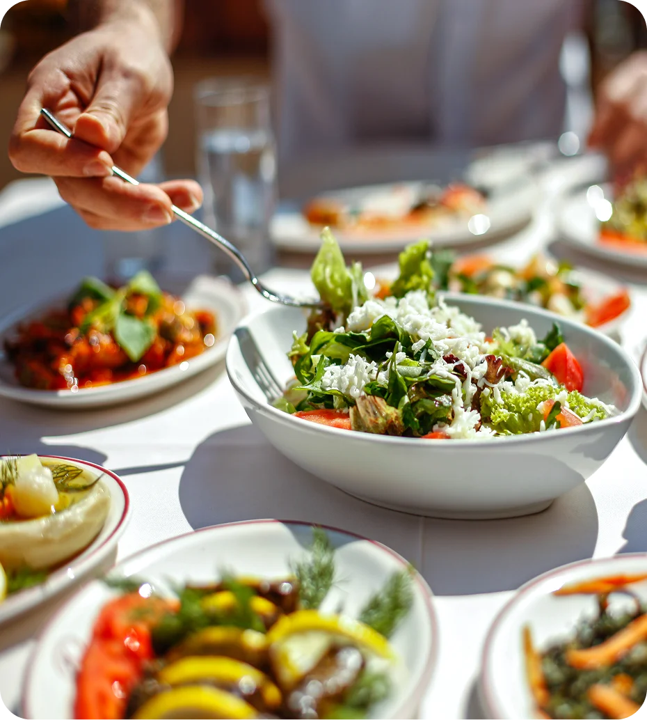 Person serving fresh salad at table.