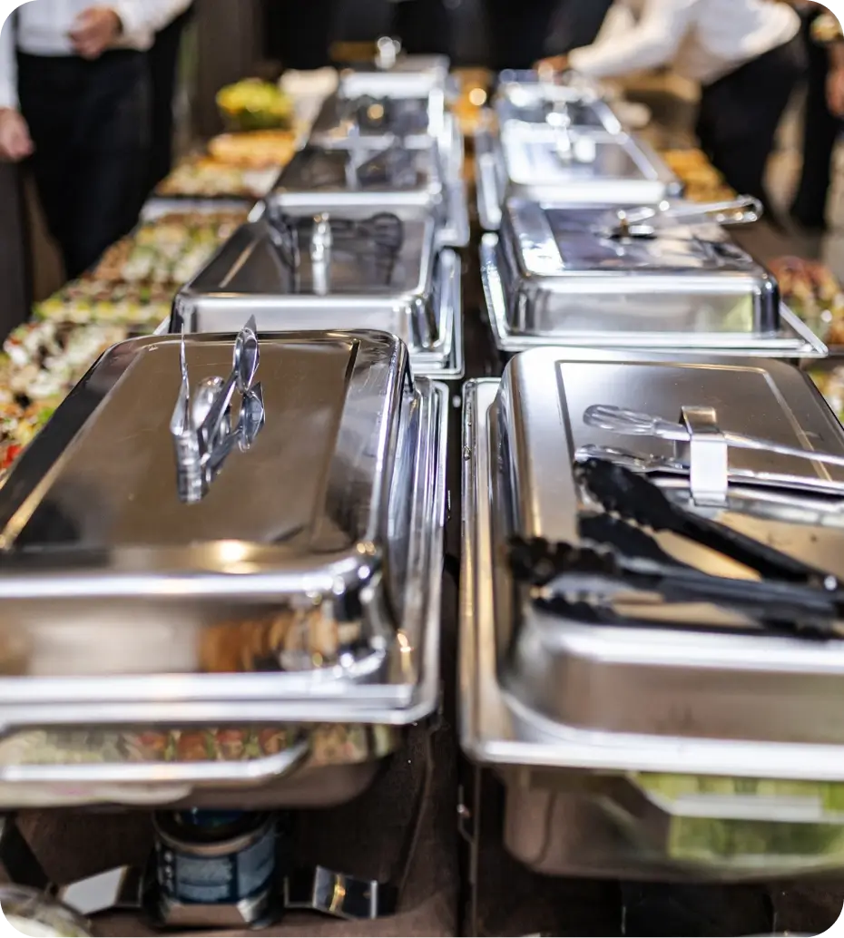 Buffet table with covered chafing dishes.